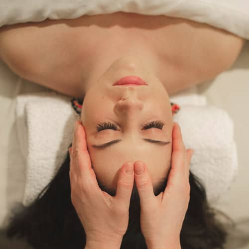 Hands on face during spa facial treatment, The Spa