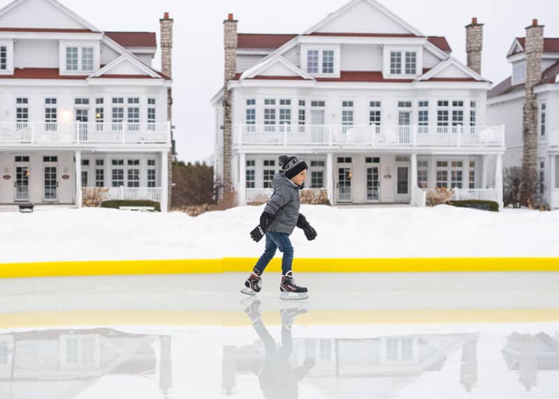 Young boy ice skating at outdoor rink in Bay Harbor, MI