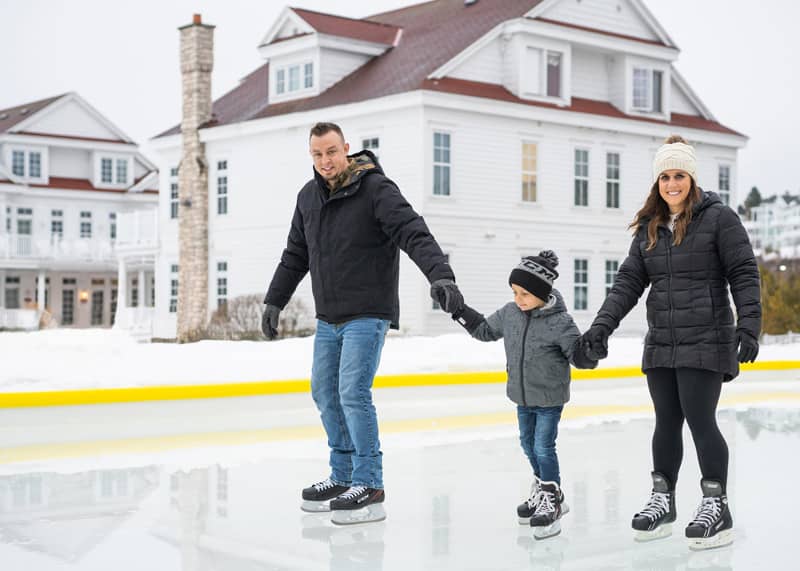 Parents ice skating with son at outdoor rink in Bay Harbor, MI