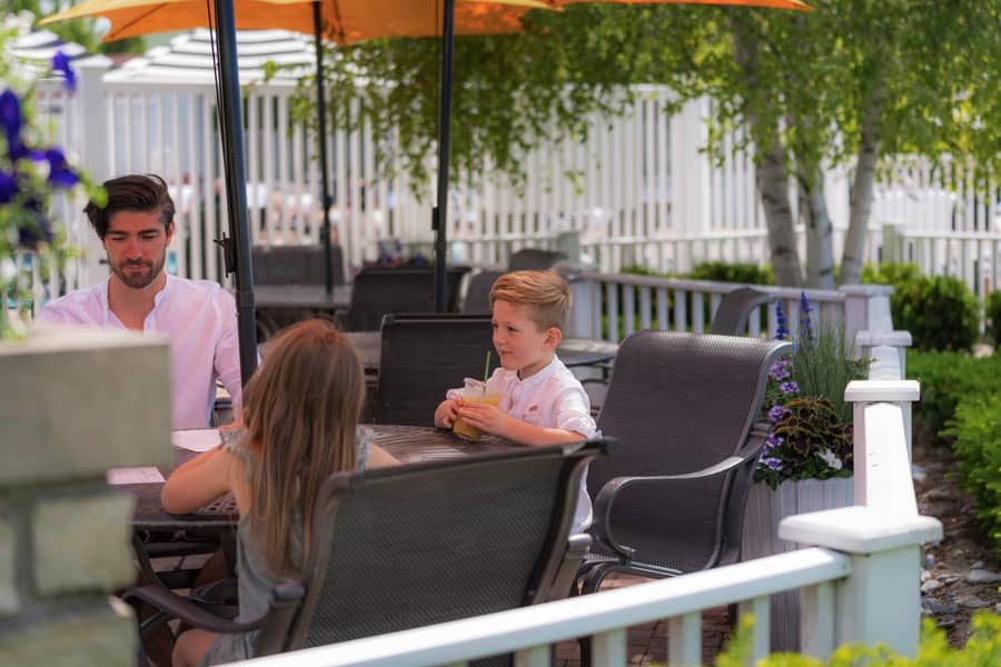 Children enjoy food and drinks at outdoor Cabana Bar in summer, Inn at Bay Harbor