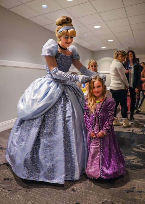Cinderella crowns a young guest princess for the day, during Crowning Moment add-on.