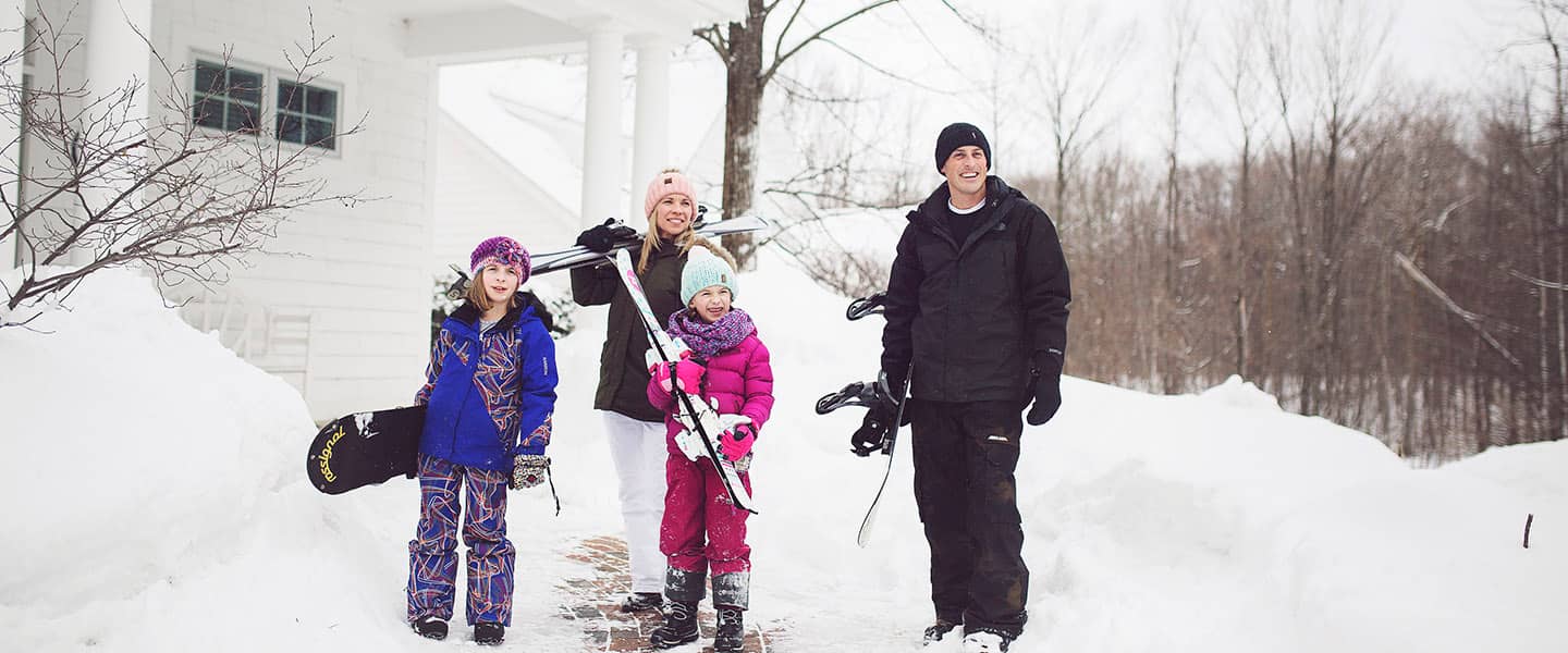 Family carries ski gear outside Cottages at Bay Harbor, near Petoskey Michigan