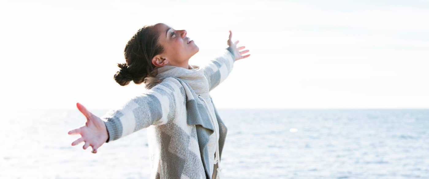 Woman with arms outstretched in front of Lake Michigan