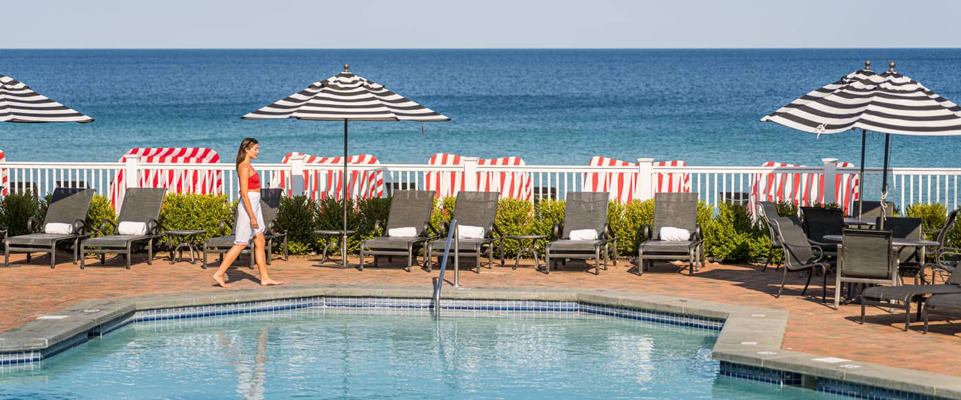 Woman walking on lakefront pooldeck, Inn at Bay Harbor